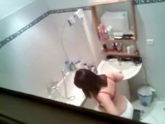 Gorgeous brunette getting ready to take hidden shower