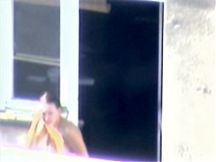 Nude titted minx caught on cam on the balcony