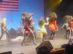 Painted boobs bounce around on the stage at a rock concert