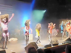 Painted boobs bounce around on the stage at a rock concert