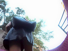 Upskirt in the stairs of aleather skirt