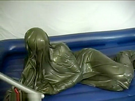 Woman struggling in a green latex bag