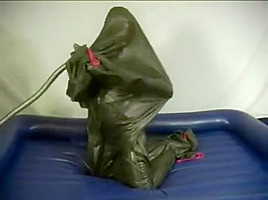 Woman struggling in a green latex bag