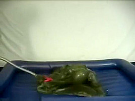 Woman struggling in a green latex bag