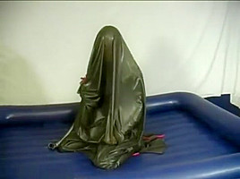 Woman struggling in a green latex bag