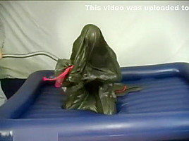 Woman struggling in a green latex bag