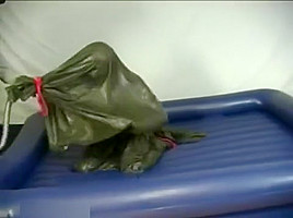 Woman struggling in a green latex bag
