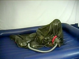 Woman struggling in a green latex bag