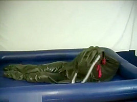 Woman struggling in a green latex bag
