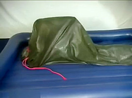 Woman struggling in a green latex bag