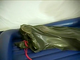 Woman struggling in a green latex bag