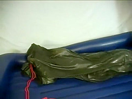 Woman struggling in a green latex bag