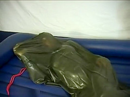 Woman struggling in a green latex bag