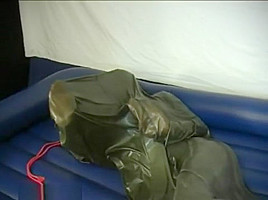 Woman struggling in a green latex bag