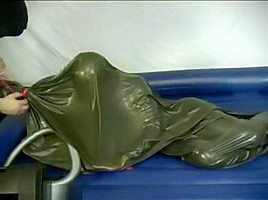 Woman struggling in a green latex bag