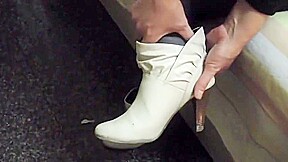 Woman takes off white sock to reveal her bandaged ankle